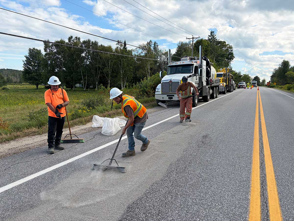 Équipe de Klondike Environnemental épandant et balayant l'absorbant sur la route 321 pendant l'intervention d'urgence